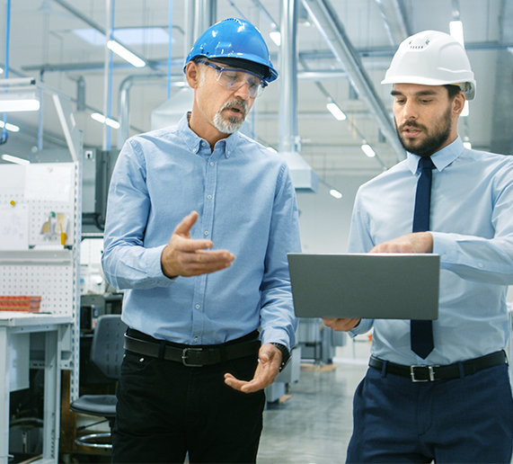Two workers in hard hats reading a chart